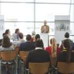 Front view of young mixed race female speaker speaking in a business seminar in modern office building