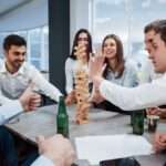 Please don't fall down. Celebrating successful deal. Young office workers sitting near the table with alcohol.